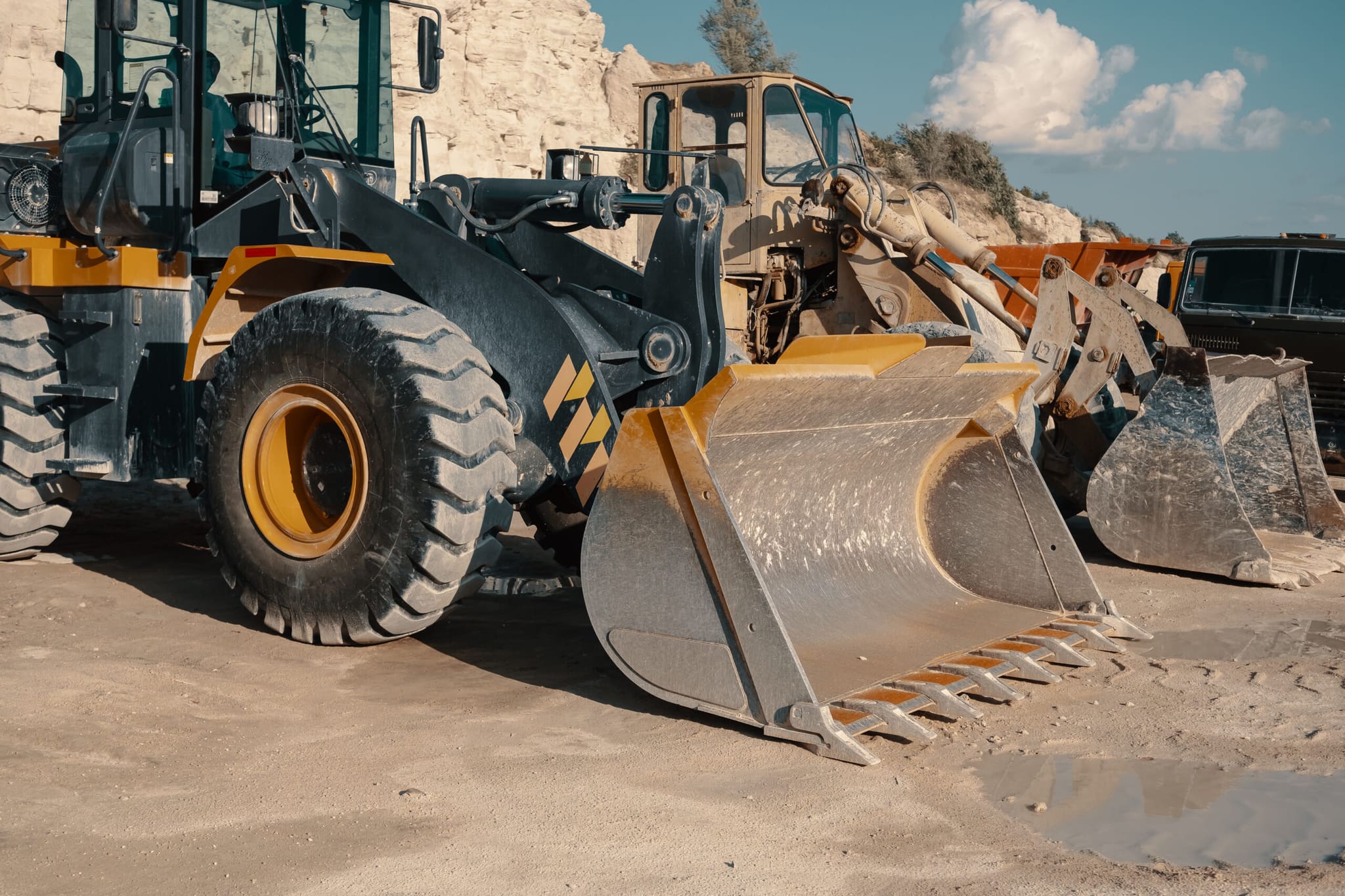 Heavy machinery loading industrial residuals at a quarry site